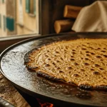 La socca nice, galette fine sur plaque brûlante, bords dorés
